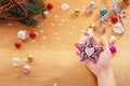 Christmas concept. Human hand hold a ceramic christmas decoration in a shape of cookie star Royalty Free Stock Photo