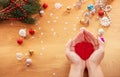 Christmas concept. Human hands hold a glass christmas decoration in a shape of heart Royalty Free Stock Photo