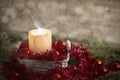Christmas concept: a lit candle lit with cross screen stars effect in a white shabby basket with red Christmas baubles, red Royalty Free Stock Photo