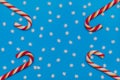 Christmas concept. Striped candy  and snowflakes on a blue background. Red and white caramels. Flat lay, copy space, top view. Royalty Free Stock Photo