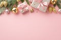 Christmas concept. Top view photo of stylish gift boxes with ribbon bows fir branches in frost gold pink baubles balls pine cone Royalty Free Stock Photo