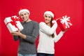 Christmas Concept - Young attractive couple giving gifts to each other celebrating in Christmas day Royalty Free Stock Photo