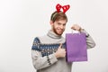 Christmas Concept - Young handsome beard man happy with shopping bag in the hand isolated on white. Royalty Free Stock Photo