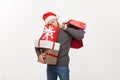 Christmas Concept - young handsome man with beard holding heavy presents with exhausted facial expression on white Royalty Free Stock Photo