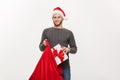 Christmas Concept - Young happy beard man excite with big present in santa bag.