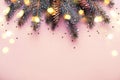 Christmas coniferous border with cones and bokeh lights. Pink background Royalty Free Stock Photo