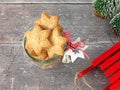 Christmas Cookies in Glass Jar, Sledge and Fir Trees on Wood