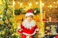 Christmas cookies and milk. Little Santa Claus kid with beard and mustache. Santa in home. Santa Claus - bearded funny