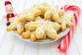 Christmas cookies in a plate, with Christmas decoration: a wooden Santa Claus and a candy cane Royalty Free Stock Photo