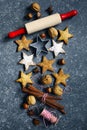 Christmas cookies, roller pin, cinnmoa, nuts and cookie cutter on dark background Royalty Free Stock Photo