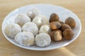 Christmas cookies, tasty balls with hazelnut inside and icing sugar, white plate and wooden table Royalty Free Stock Photo