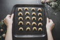 Christmas cookies. Top view of female hands holding baking sheet with raw Christmas homemade cookies ready to bake Royalty Free Stock Photo