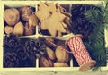 Christmas cookies, walnuts, nuts and pine cones in wooden box.