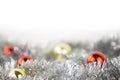 Christmas copy space with red and gold bright baubles in silver decorative chain on bottom on white background and bokeh effect Royalty Free Stock Photo
