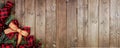 Christmas corner border banner with red and black checked buffalo plaid ribbon, burlap and branches, top view on a wood background