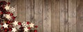 Christmas corner border banner with wood star ornaments and red baubles, above view on a wood background Royalty Free Stock Photo