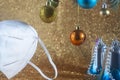 Christmas coronavirus concept, white medical respirator, near colorful christmas tree toys, self-isolation Royalty Free Stock Photo