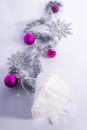 Christmas coronavirus concept, white respirator with purple decorations, over white background. Vertical shot Royalty Free Stock Photo