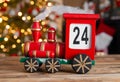 Christmas countdown. Wooden train Christmas advent calendar, with tree lights bokeh.