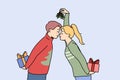 Christmas couple with gift boxes kisses and holds fir cones in hands and exchange new year presents