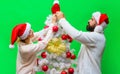 Christmas couple man and woman in Santa hat decorating Christmas tree together at home. Winter holidays. Christmas or Royalty Free Stock Photo