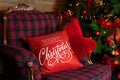 Christmas coziness. Close up Christmas red pillow on sofa. Decorated living room with a Christmas tree. Interior of room with beau Royalty Free Stock Photo