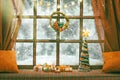 christmas cozy interior background with window tree illuminated with lights and gift boxes Royalty Free Stock Photo