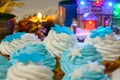 Christmas cream cakes and candles close up on the table with colored lights