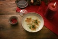 Christmas cream soup with toasted bread in star shape, parsley garnish and pomegranate seeds, wine glass and burning candle on a