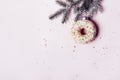 Christmas creative background. Christmas ball made of decorated donut hanging on Christmas tree branch