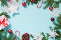 Christmas border with white and red decor, balls, gift, candy cane, snowflakes on blue. Flat lay. Top view. Copy space. Royalty Free Stock Photo