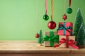 Christmas creative concept with gift boxes composition as Christmas tree and hanging ornamnet decoration on wooden table over