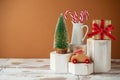 Christmas creative concept with toy car, pine tree and gift box on geometric podium on wooden table