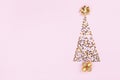 Christmas creative fir tree from confetti stars, serpentine and golden balls on pink background top view. Flat lay. Royalty Free Stock Photo