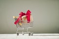 Christmas creative minimal composition. Shopping cart and Xmas gift, red satin bow on black background. Christmas, New Year, Royalty Free Stock Photo