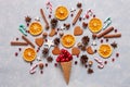 Christmas creativity concept with red balls, candy canes, cookies, spices, dry orange slices in the waffle. Flat lay, Close-up