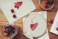 Christmas cross stitch designs and decorations on wooden table. Preparing handmade gifts for New Year and Christmas