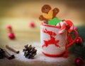 Christmas Cup ornament and a fun gingerbread on a wooden table Royalty Free Stock Photo