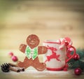 Christmas Cup ornament and a fun gingerbread on a wooden table Royalty Free Stock Photo