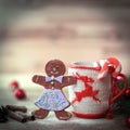 Christmas Cup ornament and a fun gingerbread on a wooden table Royalty Free Stock Photo