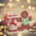 Christmas Cup ornament and a fun gingerbread on a wooden table Royalty Free Stock Photo