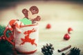 Christmas Cup ornament and a fun gingerbread on a wooden table Royalty Free Stock Photo