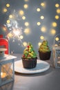 Christmas cupcake with burning sparkler on green cream tree with cowberry decor