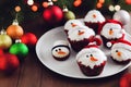 Christmas cupcakes with Santa hat and snowman on wooden background