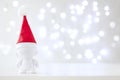 Christmas cute toy in Red Hat Santa Claus, Symbol New Year, Defocused Lights White Background Royalty Free Stock Photo