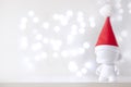 Christmas cute toy in Red Hat Santa Claus, Symbol New Year, Defocused Lights White Background Royalty Free Stock Photo