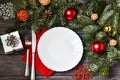 Christmas cutlery with a plate and a red napkin on a wooden background. New year and christmas concept. Royalty Free Stock Photo