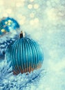 Christmas dark blue balls with sparkles on white snow and snow-covered pine branches. Blurred background and yellow Royalty Free Stock Photo