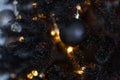 Christmas dark blurred background with a black Christmas tree, ornaments and bokeh lights Royalty Free Stock Photo