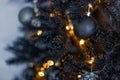 Christmas dark blurred background with a black Christmas tree, ornaments and bokeh lights Royalty Free Stock Photo